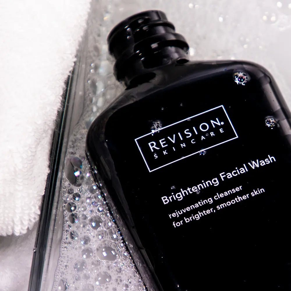 Revision Skincare Brightening Facial Wash bottle – exfoliating face cleanser with glycolic and salicylic acids to brighten and refresh skin with bubbles on a white background